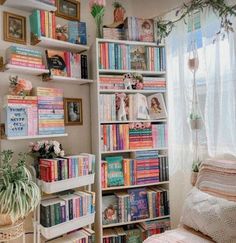 a book shelf filled with lots of books next to a window and a bed in front of it