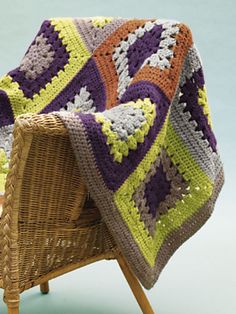 a crocheted blanket sitting on top of a wicker chair