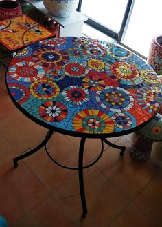 a table that has been decorated with colorful designs on it and is sitting in front of a window