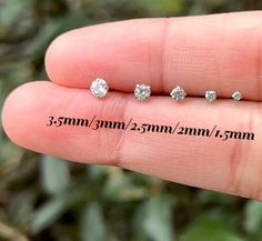 three diamond studs are shown in the palm of a person's hand,