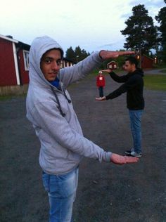 two people standing in the middle of an empty lot with one person holding out his hand