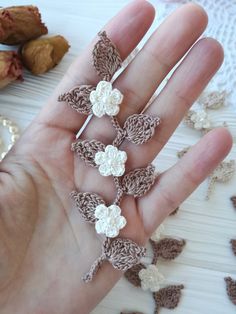 the hand is holding several pieces of crocheted jewelry on it's palm