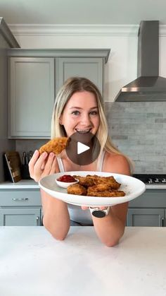 a woman sitting at a kitchen table with a plate of food