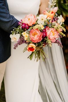 a bride and groom holding a bouquet of flowers