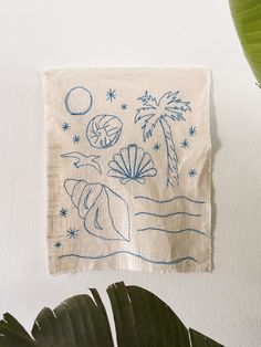 a white wall hanging with blue drawings on it