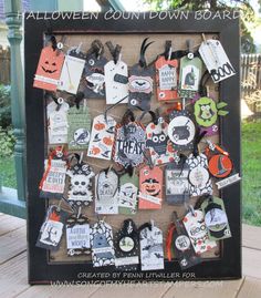 a shadow box filled with lots of halloween themed tags and magnets on a wooden table