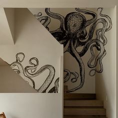 an octopus mural is painted on the wall next to some stairs in a house with white walls