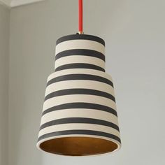 a black and white striped light hanging from a ceiling fixture with a red cord attached to it