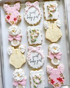 baby shower cookies decorated with pink and white icing on a baking sheet in a box