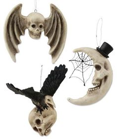 two halloween decorations with skulls and a bird on the top one has a skull in it's mouth