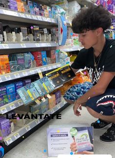 a young boy sitting on the floor in front of a display of toothpaste