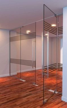 an empty room with wooden floors and glass partitions