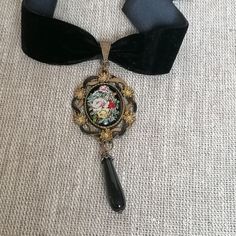 This gorgeous Victorian/Gothic style black velvet choker with a flower cameo placed in an antique gold and back hand painted pendant finished with black agates teardrop by a will definitely draw everyone's attention to whatever the rest of the garment of your choice for the event attended might be.  Detailed, hand crafted and carefully designed.  Measurement Pendant length----3,5 inches (9 cm) choker length----14 inches (37 cm) Closed with adjustable lobster claw, but size can always be changed Victorian Metal Choker For Gift, Victorian Metal Choker As Gift, Victorian Metal Choker Gift, Victorian Style Adjustable Choker Jewelry, Black Pendant Necklace With Vintage Charm, Antique Adjustable Choker As Gift, Adjustable Victorian Style Choker Jewelry, Victorian Cameo Jewelry For Party, Victorian Black Choker Jewelry