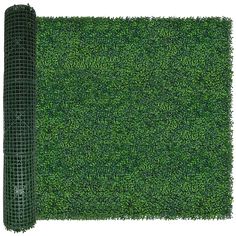 a roll of green grass on top of a white surface with a mesh fence around it