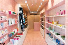 the inside of a pink store with shelves filled with books and other items on display