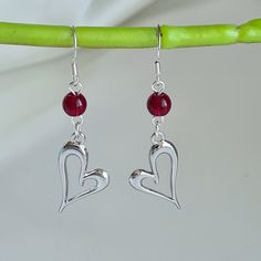 ♡Pretty silver heart earrings handmade with a garnet stone. The silver plated heart is 24mm x 15mm and the garnet natural stone 8mm. Total earring drop is 43mm and width 10mm. ♡Earring hooks are 925 sterling silver and ear nuts are silicone which are hypoallergenic - Great for sensitive ears. ♡Cute pair of earrings perfect for everyday wear or as a gift and come with a lovely velvet gift pouch. ♡Note colours may vary due to individual monitors but please contact me with any queries.  ♡Free shipp Sterling Silver Heart Beads Dangle Earrings, Valentine's Day Gift Heart Sterling Silver Earrings, Red Sterling Silver Dangle Heart Earrings, Sterling Silver Heart Earrings With Heart Beads, Sterling Silver Heart-shaped Earrings With Heart Beads, Elegant Sterling Silver Heart Birthstone Earrings, Sterling Silver Earrings For Valentine's Day, Valentine's Day Sterling Silver Dangle Heart Earrings, Silver Heart Beads Earrings For Anniversary