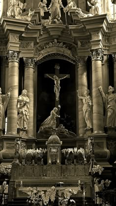 an ornate church with statues around it and a crucifix in the center