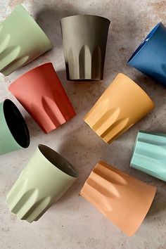 six different colored cups sitting on top of a table next to each other in a circle