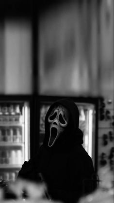 a person wearing a mask in front of an open refrigerator with its mouth wide open