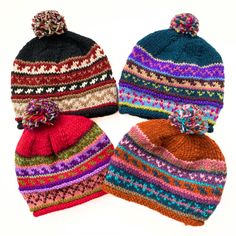 three knitted hats with pom poms on top of each one in different colors