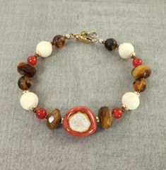 Handmade bracelet in rustic earth tones. Beads are tigers eye, carnelian, ceramic, glass, bone, and 14KT gold filled metal.  Bracelet has two links and is designed to fit as a 7 or 7 1/2 inch bracelet depending on where you close it. Closes with a 14KT gold filled lobster style clasp. Thank you for stopping by! Find more handmade bracelets here - http://www.etsy.com/shop/CharleneSevier?section_id=10084259 Join my newsletter for a 20% off coupon and to receive news about new items and sales. Copy and paste this URL in your browser - https://lp.constantcontactpages.com/sl/guuquqO ---------------------------------- PLEASE READ: This item is not intended for children where choking is a hazard. ---------------------------------- Cheap Everyday Brown Bracelets, Cheap Adjustable Brown Bracelets, Cheap Brown Bracelet Jewelry, Fall Brown Bracelets, Cheap Brown Round Beaded Bracelets, Earth Tones Jewelry, Luxury Handmade Brown Bracelets, Luxury Brown Round Beads Bracelets, Luxury Brown Round Bead Bracelets