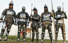 five men dressed in medieval armor standing next to each other