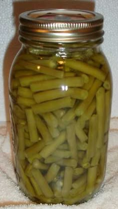 a jar filled with pickles sitting on top of a towel