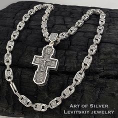 a cross on a chain is shown with the words art of silver levisity jewelry