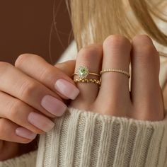 a woman's hand with two rings on her fingers and one ring in the middle