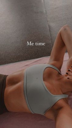 a woman laying on top of a pink mat in a gym setting with the words me time written above her