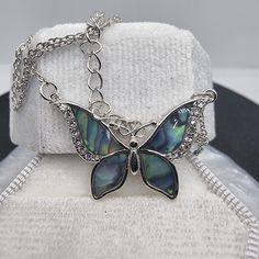 Dive into the mesmerizing beauty of the ocean and the sky with our Abalone Shell Blue Butterfly Necklace, a masterpiece forged in 925 Sterling Silver. Each flutter of the butterfly's wings reveals the ethereal dance of abalone shell's oceanic blues, accented with glimmers of crystal that catch the light like morning dew on a cobweb. The butterfly, an emblem of transformation and the promise of new beginnings, is poised in eternal grace, wings unfurled in a display of nature's unparalleled design Blue Butterfly Necklace, Vibrant Butterfly, Mesmerizing Beauty, Butterfly Necklace, Abalone Shell, Sparkling Crystal, Blue Butterfly, Butterfly Wings, The Butterfly