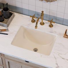 a bathroom sink sitting under a mirror next to a faucet and soap dispenser