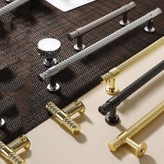 several different types of handles and knobs on a piece of fabric with gold trim