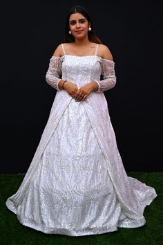 Its a stunning floor-length outfit made from Net fabric in an elegant White color. It features a Off -Shoulder Neck at the front and a Deep Neck at the back. The gown is designed with Cold Shoulder sleeves style. It is embellished with intricate work including Cutdana, Sequins, and Stone work, making it a beautiful choice for special occasions and events. Complete the look by wearing Stone jewelry and bracelet. There might be little color variations in the image and original product due to photo Embellished Floor-length Gown For Reception, Embroidered Floor-length Gown With Fitted Bodice, White Floor-length Dress For Reception, Embroidered Ball Gown With Fitted Bodice, Embroidered Maxi Evening Dress For Reception, Embellished Floor-length Lehenga With Fitted Bodice, Embellished Lehenga With Fitted Bodice And Floor-length, Embellished Lehenga With Fitted Bodice, Embroidered Gown With Fitted Bodice For Reception