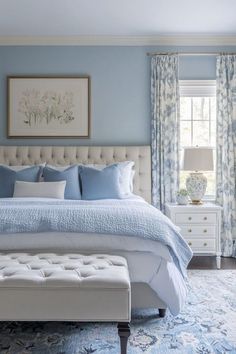 a bedroom with blue walls, white furniture and a large bed in the center of the room