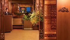 a man standing at a podium in an ornately decorated lobby