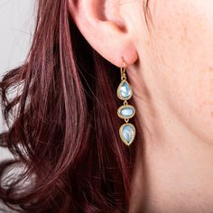 Three one-of-a-kind Aquamarine gemstones make up these trio earrings, reminiscent of cool, crystalline waters. Each stone has been set in a handmade 18k gold bezel with braided detail. Technical Details Metal: 18k yellow goldAquamarine: 5.07 cts.Total Length: 41mmEarewire: 18k french hookHandmade in New YorkStyle # E-2394-AQ Gold Aquamarine Jewelry With Bezel Setting, Three-stone Aquamarine Jewelry For Gift, Three Stone Aquamarine Jewelry As A Gift, Three Stone Aquamarine Jewelry For Gift, Gold Aquamarine Jewelry With Gemstone Accents, Teardrop Three Stone Jewelry Gift, Teardrop Three Stone Jewelry For Gifts, Fine Jewelry Aquamarine Three Stone, Gold Aquamarine Gemstone Earrings