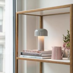 a shelf that has some books and a lamp on it