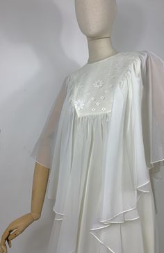 DETAILS - long sheer cape over a sleeveless empire style dress - back zip closure  - floral embroidery yoke - fully lined - poly organza/ viscose  - handmade - dated late 60s early 70s SIZE & MEASURES item laid flat on one side - fits size XS/ S measures available soon CONDITION Excellent vintage condition. Summer Dresses With Floral Embroidery And Cape Sleeves, Vintage Sheer Chiffon Dress, Vintage Summer Dresses With Sheer Sleeves, Spring Chiffon Dress With Cape Sleeves, Summer Vintage Dresses With Sheer Sleeves, Spring Wedding Dresses With Cape Sleeves, Spring Dress With Cape Sleeves And Floral Embroidery, Spring Cape Dress In White, White Cape Dress For Spring