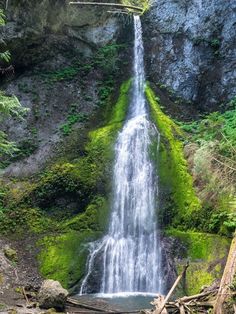 a waterfall with green moss growing on it