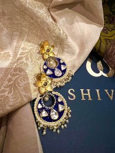 These gorgeous earrings will add a perfect charm to your occasion wear. You will definitely fall in love with this beauty and it will make you stand out among the crowd. Length: 6.5 cms Width: 3.5 cms One of a kind. The uncut Kundan stones embellished on a blue meenakari (enameled) base with pearl drop clusters make it a statement pair. The earrings are the same as shown in the pictures. We have only one piece in this design and color, hence you get what you see in the pictures. Fusion Kundan Pearl Earrings For Wedding, Fusion Pearl Earrings With Meenakari For Celebrations, Fusion Style Pearl Earrings With Meenakari For Celebration, Fusion Style Meenakari Pearl Earrings For Celebrations, Fusion Style Hoop Earrings For Festivals And Celebrations, Fusion Style Hoop Earrings For Celebrations And Festivals, Festive Fusion Hoop Earrings For Celebration, Elegant Chandbalis With Gota Work For Celebrations, Fusion Style Chandbalis With Latkans For Celebration