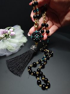 Beautiful sautoir necklace with long tassel. The main elements of this necklace are two: a large 30 mm pearl covered in beads and crystals and a splendid black tassel with Marcasite. These crystals give a lot of brightness and make the necklace very elegant. The pearl is covered by hand with different types of beads, a precision and difficult job to perform. The necklace is made with black agate beads of different sizes and crystals. Some points are highlighted with the beautiful emerald green color which gives a mystical look to the necklace. Everything matches perfectly, colors and shapes. The closure is an 18K gold-plated opening ring. The pendant with the ball and the tassel can be removed if desired and you can only wear the simple necklace. The necklace is very elegant, perfect for l Elegant Party Necklace With 108 Beads, Elegant Necklace With 108 Beads For Party, Elegant Handmade Black Long Necklace, Elegant Black Tassel Necklace For Party, Elegant Jewelry With Tassels And Round Beads, Elegant Round Beaded Tassel Jewelry, Elegant Necklace With 108 Beads Pendant, Elegant Black Tassel Necklace, Elegant Tassel Necklace With Round Beads