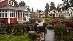 a row of red houses sitting next to each other on top of a lush green field