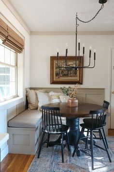 a dining room table with four chairs and a bench in front of the couches