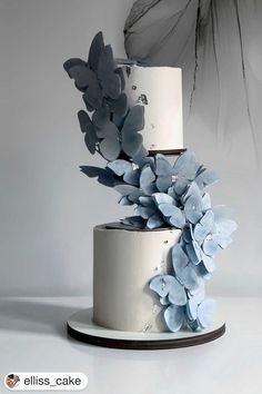 a three tiered cake with blue flowers on top