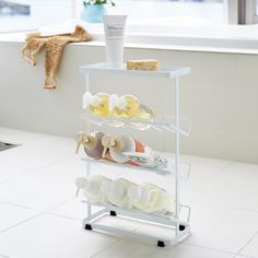 there is a white shelf with several pairs of shoes on it and a towel rack in the corner