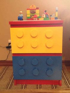 a toy chest made out of legos on the floor next to a rug and wall