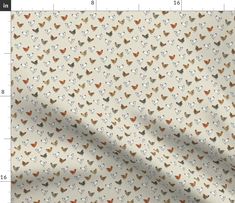 a white fabric with orange and grey butterflies on it, as well as a ruler