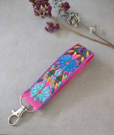 a pink key chain with flowers on it