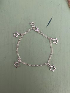 This is a handmade silver star charm bracelet. It's perfect on its own or for additional charms! Metal Charm Bracelet, Star Charm Bracelet, Handmade Silver Dainty Charm Bracelet, Silver Handmade Charm Bracelet For Everyday, Handmade Silver Charm Bracelet For Everyday, Dainty Silver Charm Bracelet With Dangling Charms, Dainty Handmade Silver Charm Bracelet, Adjustable Silver Chain Bracelet With Dangling Charms, Silver Adjustable Chain Bracelet With Dangling Charms